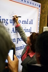 Premier Christy Clark adds her name to a banner stating a commitment to end viol