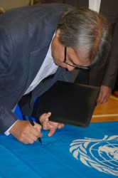 United Nations Special Rapporteur James Anaya signs United Nations flag