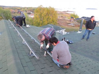 Installing the eight solar photovoltaic panels on the south-facing roof