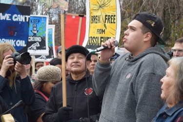 Cedar George-Parker (centre), a youth from Tsleil-Waututh Nation, speaks to a cr