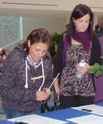 Vivian Tuccaro, with Chelsea Hawrelak, signs the petition calling for a national