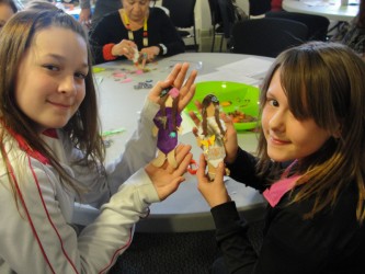 Two young girls attend the workshop with their family and show-off their faceles
