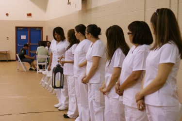 Siksika LPN students pass on a candle lantern. The light represents their journe