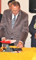 Indian and Northern Affairs Minister John Duncan places a Canadian flag into an 