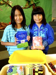 Students Rain Goodstoney (left) and Serenity Fox help with the packaging of card