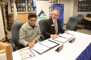 Treaty 8 Grand Chief Richard Kappo (left) and APEGGA President Jim Smith sign th