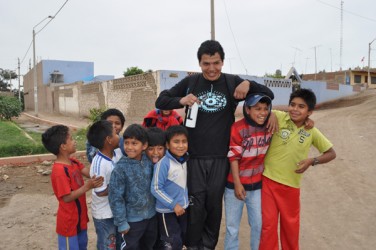 Chance Roasting with kids from Peru in front of Santa Rosa school 