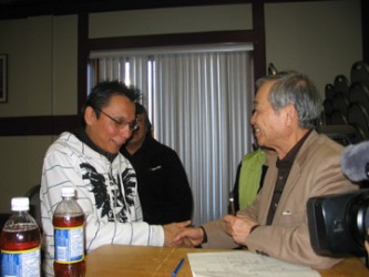 Dr. Masazumi Harada (right) shakes hands with Leslie Cochrane, 38, of Grassy Nar