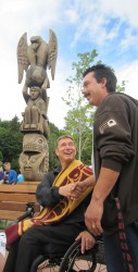 Rick Hansen shakes the hand of Phillip Baines, whose late father Corky carved th