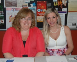 Colleen Enns (left) and Sara Parker help Métis evacuees from RMWB