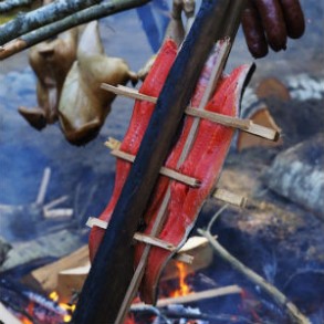 Qualicum duck, sockeye salmon and venison sausage cooking over the fire.